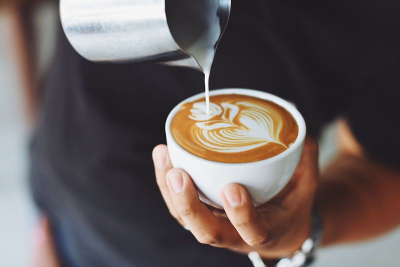 A barista pouring latte art